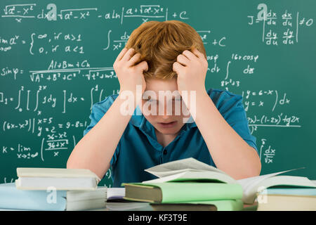 Frustrati Boy in aula con le mani sulla testa Foto Stock