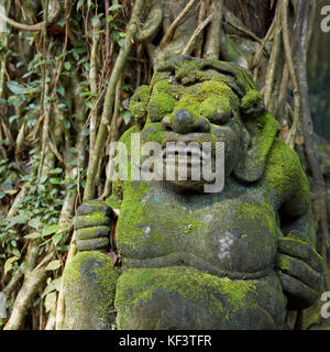 Statua in pietra mossy nel Santuario della Foresta delle scimmie Sacra. Ubud, Bali, Indonesia. Foto Stock