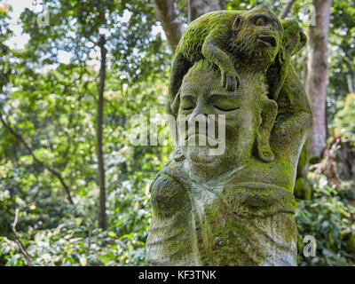 Statua in pietra mossy nel Santuario della Foresta delle scimmie Sacra. Ubud, Bali, Indonesia. Foto Stock