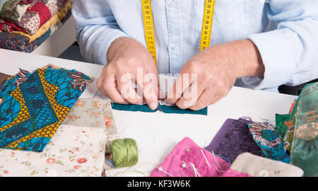 Un primo piano delle mani di un designer di moda nel suo laboratorio Foto Stock