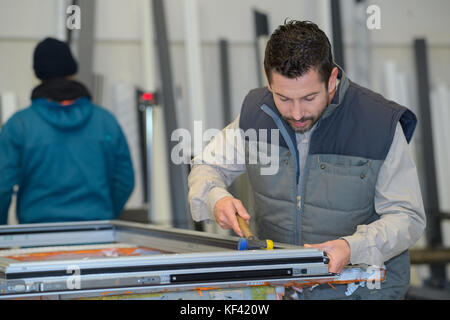 Industriali operaio di fabbrica funziona macchina punzonatrice Foto Stock