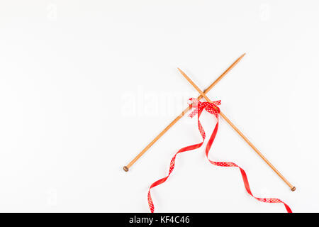 Tre cuori rossi lavorati a maglia su sfondo grigio di legno, simboleggiano  l'amore e la famiglia. Relazione di famiglia, legami. San Valentino. Aghi  per maglieria e un Foto stock - Alamy