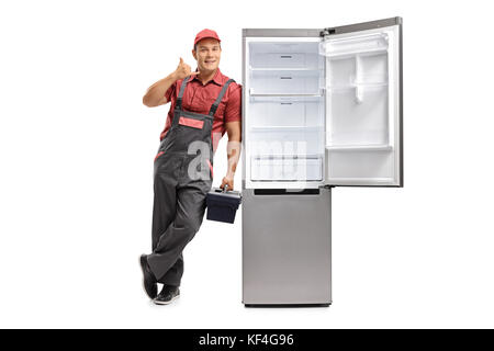 A piena lunghezza Ritratto di un veterano appoggiata contro un frigorifero vuoto e si effettua una chiamata a me gesto isolato su sfondo bianco Foto Stock