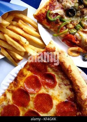 Foto di fette di pizza su una piastra e patatine fritte Foto Stock