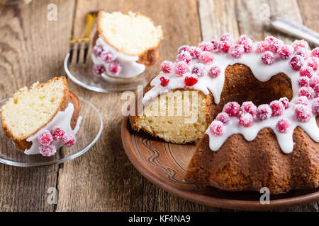 I canditi di mirtilli bundt torta al limone con glassa di zucchero sulla tavola di legno. in casa autunno e inverno vacanza piacevole dessert su tavolo rustico Foto Stock