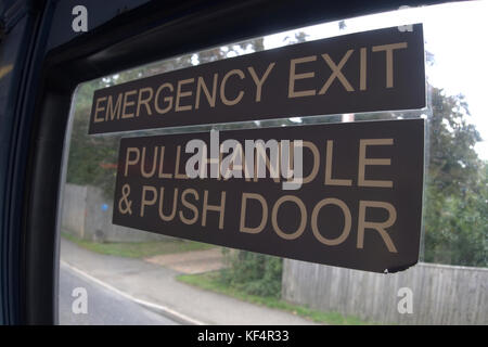 Uscita di emergenza segno su un bus del Regno Unito la lettura di tirare la leva e spingere la porta Foto Stock
