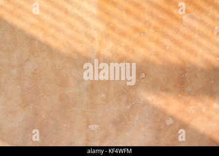 Ombre sul pavimento di cemento di sfondo - le ombre delle barre di finestra su un vecchio cemento intonacato piano formando una configurazione di linee. Foto Stock