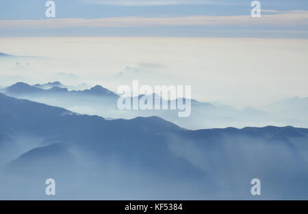 Mattinata nebbiosa nelle Alpi Italiane Montagne - mountain range sagome Foto Stock