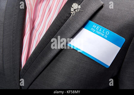 La donna vestita di nero business suit e rosa e bianca a strisce shirt e fantasia pin argento indossando plain vuoto Foto Stock