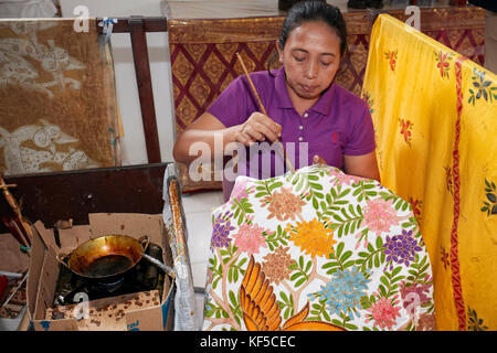 Craftswoman pittura batik. Villaggio di Batubulan, area di Ubud, Bali, Indonesia. Foto Stock