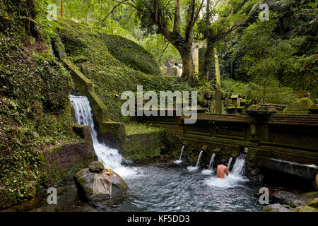 Uomo del posto che fa il bagno nella parte maschile della piscina del tempio di Mengening. Tampaksiring, Bali, Indonesia. Foto Stock