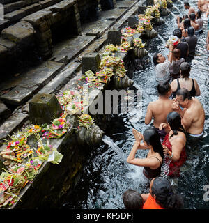 Persone che fanno purificazione rituale nella sorgente Santa. Tirta Empul Tempio, Tampaksiring, Bali, Indonesia. Foto Stock
