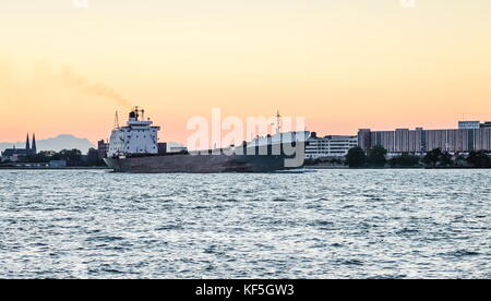 Detroit, MI, Stati Uniti d'America - 1 ottobre 2016: il tecumseh portarinfuse nave nani grandi edifici sul Fiume Detroit al tramonto visto da Windsor, Ontario, Foto Stock