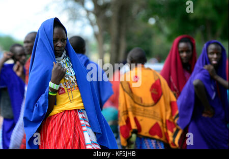 Maasai tribesmen in un colorato bovini e prodotti freschi di mercato nel nord della Tanzania. Foto Stock