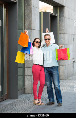Matura in piedi sul sentiero azienda multi-colore di borse per lo shopping Foto Stock