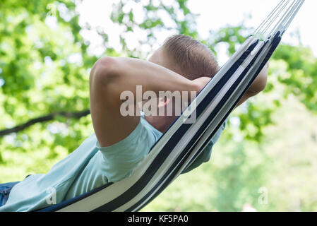 Giovane uomo rilassante in amaca in posizione di parcheggio Foto Stock