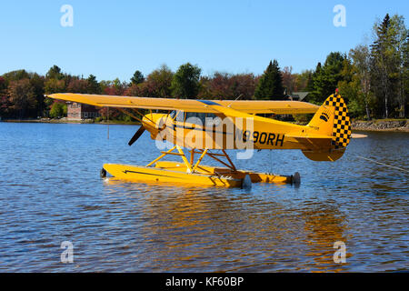 Di colore giallo brillante 2005 Cub Crafters float plane parcheggiato presso la spiaggia del villaggio in speculatore, NY. Foto Stock