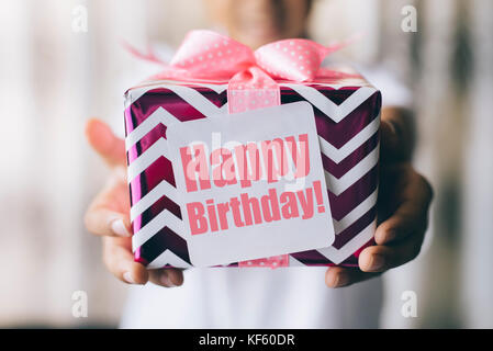 Concetto di compleanno - ragazzo giovane azienda decorate confezione regalo / presente con ' happy birthday ' nota Foto Stock