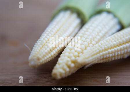 Ortaggi - close up di mais bambino su sfondo di legno Foto Stock