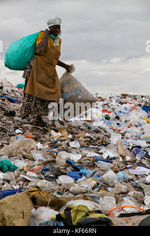 Vivere in Kenya Slum Aerias - Donna la raccolta di materiali sul più grande discarica, Dandora Dumpsite, Mairobi Kenya Foto Stock