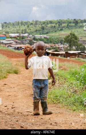 Vivere in Kenya Slum Aerias - Giovane ragazzo giocando con una propria fatta il calcio Foto Stock