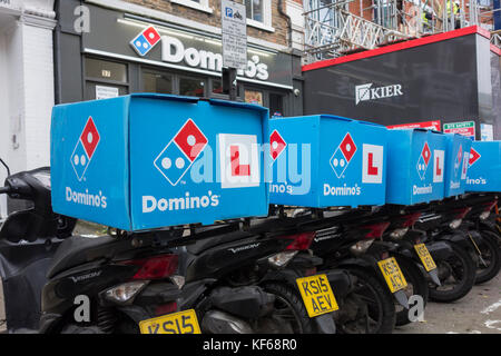 Una fila di Domino's Pizza consegna scooter in attesa al di fuori di un Domino's ristorante nel centro di Londra, Regno Unito Foto Stock