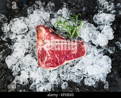 Materie carni fresche t-bone steak sul ghiaccio scheggiati Foto Stock