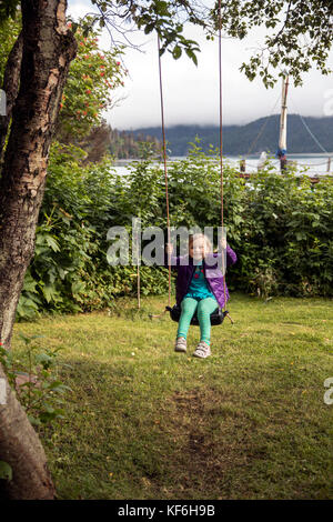 Stati Uniti d'America, Alaska, Omero, Cina poot baia Kachemak Bay, giocando sull'albero swing trovati sui motivi di Kachemak Bay wilderness lodge Foto Stock