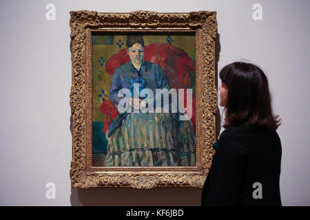 National Portrait Gallery, Londra. UK 25 Ott 2017 - UNA donna guarda Madame Cézanne in una Red Armchair c1877. Gli autoritratti di Paul Cézanne, dipinti nel 1885 e nel 1886, saranno esposti per la prima volta nel Regno Unito in una mostra, Cézanne Ritratti, alla National Portraits Gallery di Londra, giovedì 26 ottobre 2017. La mostra riunisce per la prima volta oltre cinquanta ritratti di Cézanne provenienti da collezioni di tutto il mondo. La mostra comprende anche una serie di opere che sono state esposte per l'ultima volta nel Regno Unito negli anni '20 e '30. Foto Stock