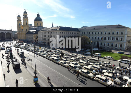 Monaco, Germania. 26 ottobre 2017. Numerosi taxi parcheggiarono durante un rally lungo la Ludwigstrasse a Monaco, Germania, il 26 ottobre 2017. La Chiesa Teatina può essere vista sullo sfondo. Centinaia di tassisti di Monaco hanno manifestato contro il controverso fornitore di servizi di trasporto Uber con un viaggio di protesta al Ministero dei trasporti bavarese. Crediti: Andreas Gebert/dpa/Alamy Live News Foto Stock