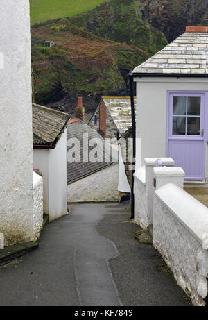 Una stretta corsia su una collina con edifici imbiancati e case su entrambi i lati nel villaggio di Port Isaac in North Cornwall. tipico villaggio della Cornovaglia. Foto Stock