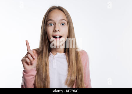 Ragazza adolescente sollevando il dito per indicare la nuova idea Foto Stock