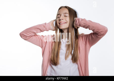 Ragazza adolescente godendo delle canzoni preferite nelle cuffie Foto Stock