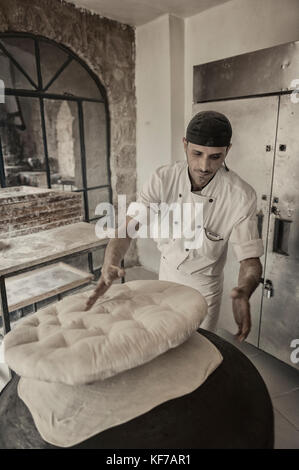 Baker preparare focacce tradizionali. Madaba, Giordania. Foto Stock