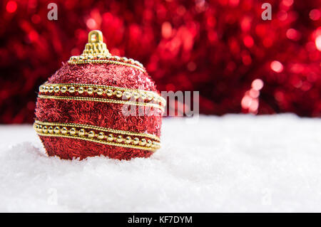 Rosso e oro palla di Natale nella neve con tinsel, sullo sfondo di Natale, Natale banner con spazio di copia Foto Stock