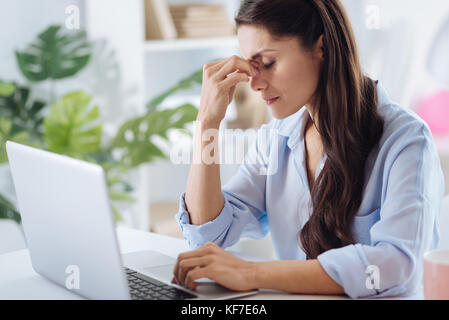 Bella donna stanchi tenendo il suo ponte di naso Foto Stock