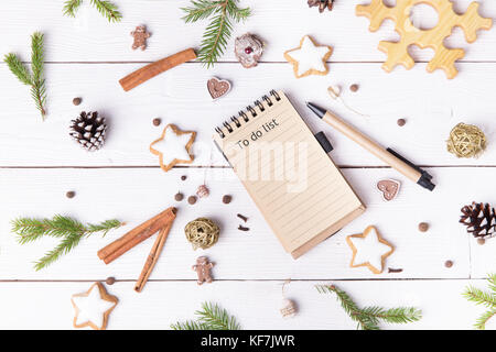 Vacanze di Natale decorazioni e notebook con Lista da fare su bianco vintage dalla tabella sopra, natale il concetto di pianificazione. Piatto stile laici Foto Stock