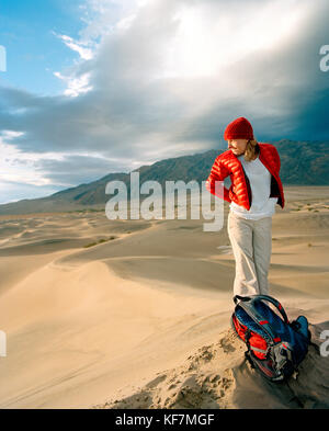 USA, California, giovane donna in piedi su duna di sabbia, stovepipe Wells, Death Valley National Park Foto Stock