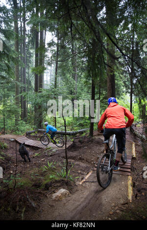 Canada Vancouver, British Columbia, Andrew baker e jordi morros mountain bike attraverso la foresta pluviale nella nebbia in North Vancouver Foto Stock