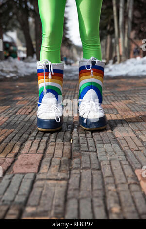 Stati Uniti d'America, colorado, Aspen, una giovane donna in verde leggings sorge nella sua moonboots nella piazza nel centro di Aspen Foto Stock