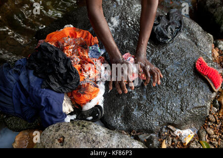 Maurizio, bois cherie, mutty megah (età 63) bagna i suoi vestiti in un piccolo ruscello dietro la sua casa Foto Stock