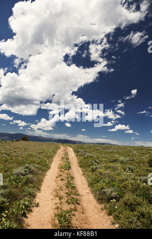 Stati Uniti d'America, Wyoming encampment, una strada sterrata che si snoda attraverso un vasto paesaggio del wyoming Foto Stock