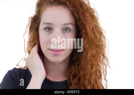 Giovane donna sta tenendo la mano tra i capelli e guardando la telecamera. ritratti. la persona è redheaded e giovani. Sfondo bianco nero shi Foto Stock