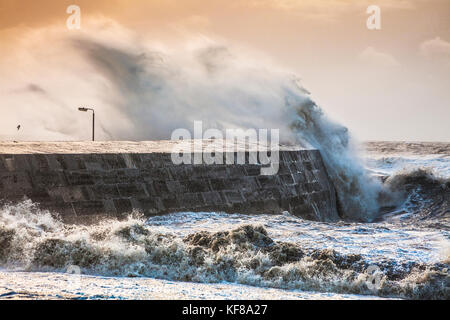 Onde infrangersi oltre il Cobb a Lyme Regis nel Dorset durante la tempesta Brian sabato 21 ottobre 2017. Foto Stock