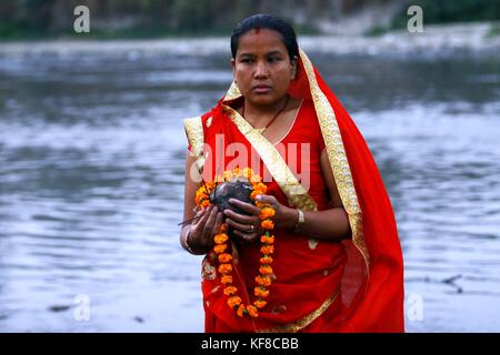 Lalitpur, Nepal. 26 ott 2017. una donna indù offre preghiere per la regolazione del sole durante il festival di chhath onorare Dio sole presso la banca del fiume Bagmati a Kathmandu, Nepal. devoti dal Terai regione del Nepal e India celebra la festa adorare Dio sole per sostenere la vita sulla terra e a prostrarsi davanti a lui per fornire la sua continua benedizione per l'umanità. Credito: archana shrestha che pacifico/press/alamy live news Foto Stock