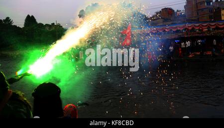 Lalitpur, Nepal. 26 ott 2017. persone bruciare petardi in celebrazione del festival chhath presso la banca del fiume Bagmati a Kathmandu, Nepal. devoti dal Terai regione del Nepal e India celebra la festa adorare Dio sole per sostenere la vita sulla terra e a prostrarsi davanti a lui per fornire la sua continua benedizione per l'umanità. Credito: archana shrestha che pacifico/press/alamy live news Foto Stock