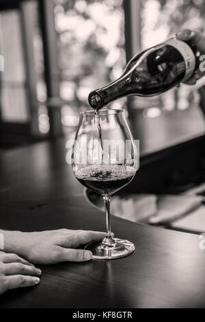 Stati Uniti d'America, oregon, willamette valley, un bicchiere di vino che viene versato presso la sala di degustazione bar, sokol blosser winery, dayton Foto Stock