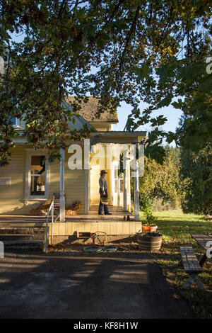 Stati Uniti d'America, oregon, Willamette Valley, Clare carver sulla parte anteriore poarch della sua cascina al grande tavolo fattorie, Gaston Foto Stock