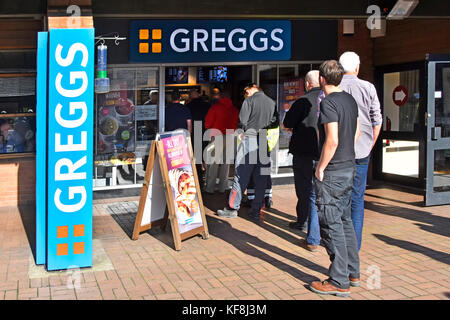 Uomini soprattutto camion camion trasporto conducente in fila per entrare Greggs food & panetteria negozio presso Lymm M6 servizi autostradali in Cheshire Inghilterra Regno Unito Foto Stock