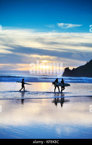 Stati Uniti d'America, oregon, Oswald west state park, surfisti a piedi lungo la spiaggia e fuori nell'acqua a oswald state park, appena a sud di Cannon Beach Foto Stock